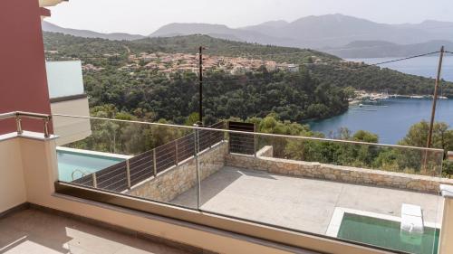 a house with a balcony with a view of a lake at Adaman Villas in Meganisi