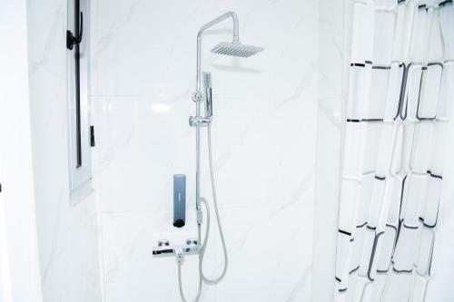 una ducha con cabezal de ducha en un baño en El Residanciel Palmiers 1, en Douala