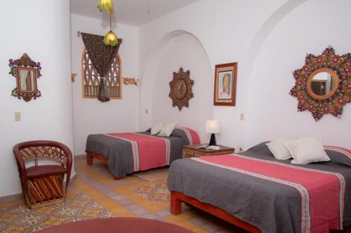 a room with two beds and a mirror on the wall at El MURO MAJAHUA RETREAT CENTER in La Majahua