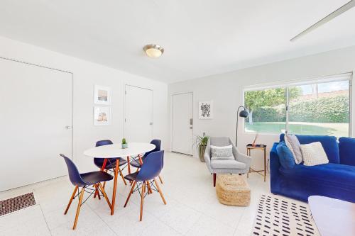 a living room with a blue couch and a table and chairs at The Dunes in Bermuda Dunes