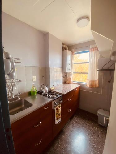a small kitchen with a sink and a stove at TU CASA EN ESPAÑA Y PEATONAL - COCHERA PRIVADA INCLUIDA - Microcentro in Mendoza