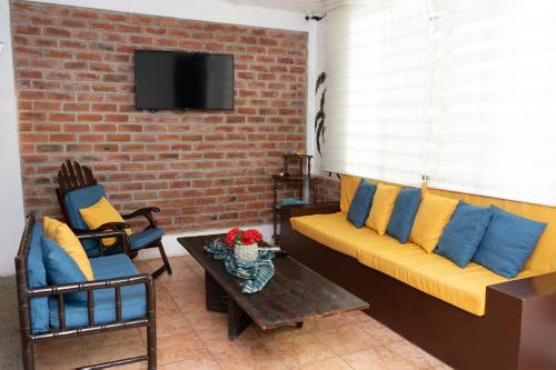 a living room with a couch and a brick wall at Hotel Estación del Sol in Las Núñez