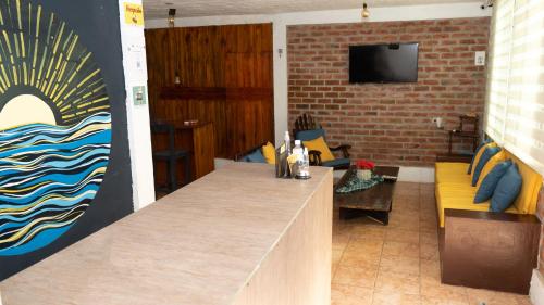 a room with a bar with a couch and a tv at Hotel Estación del Sol in Las Núñez
