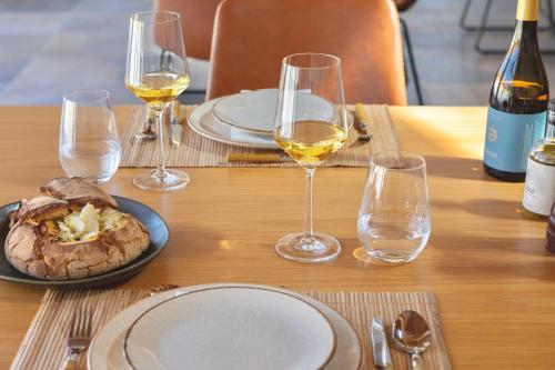 a table with glasses of wine and a plate of food at Resort Rural Quinta do Carrascal in Santarém