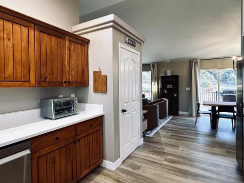 a kitchen with wooden cabinets and a counter top with a microwave at Beehive Basecamp Explore Ski Play and Make Memories in Parowan
