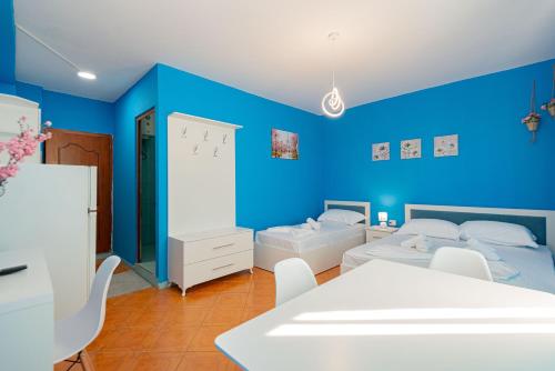 a blue bedroom with two beds and a table at VILA AL2 in Durrës