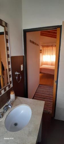 a bathroom with a sink and a room with a bed at La Placita in Córdoba