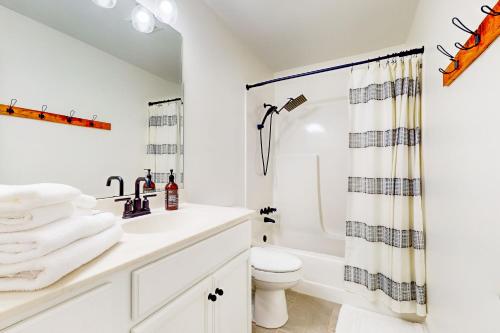 a white bathroom with a sink and a toilet at Wilma in Wrightsville Beach