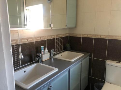 a bathroom with two sinks and a toilet at Well presented 3 Bed House- 9 Guests - Great for Leisure stays or Contractors -NG8 postcode in Nottingham