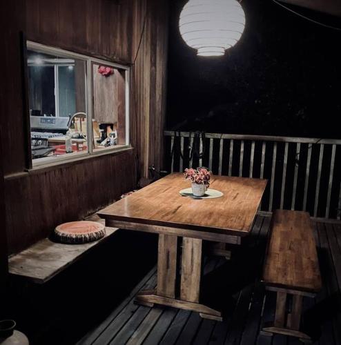 a wooden table with a vase of flowers on it at Cabin on the American Riviera in Carpinteria