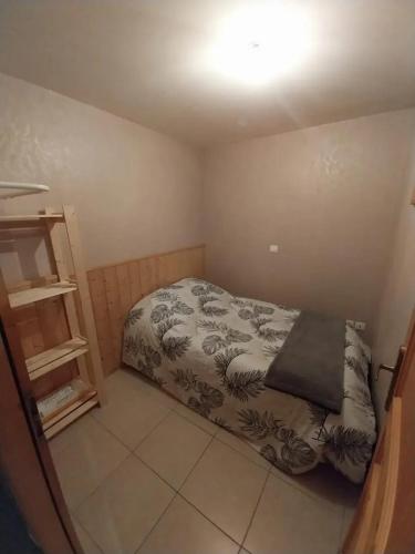 - une petite chambre avec un lit et une étagère dans l'établissement Appartement cosy à Les Belleville 48 m² avec terrasse privée, à Planvillard