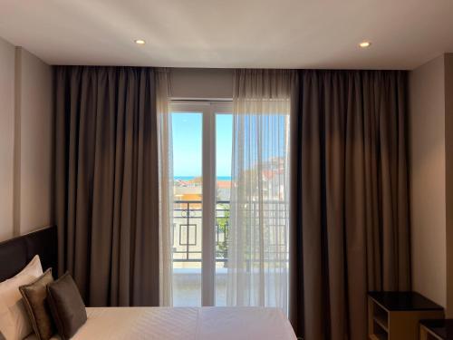 a bedroom with a bed and a large glass window at Coastline Luxury Apart Hotel in Golem
