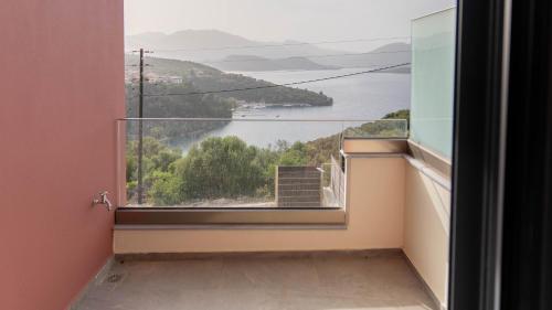 a room with a large window with a view of the water at Adaman Villas in Meganisi