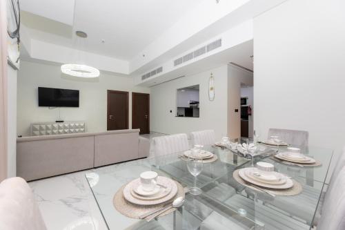 a dining room with a glass table and a television at GLOBALSTAY J One Tower Apartments at Pearl of UAE in Dubai