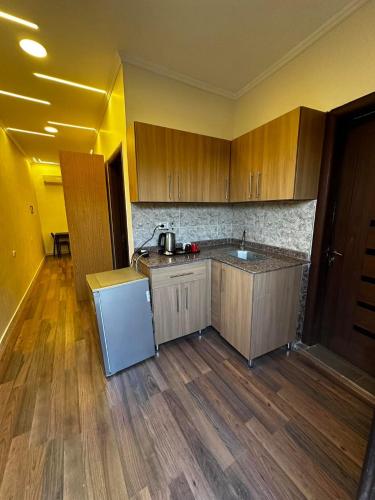 a kitchen with wooden cabinets and a white refrigerator at Narmer Pyramids View in Cairo