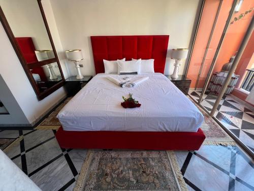 a bedroom with a large bed with a red headboard at Appart-Hotel luxe à l’hivernage in Marrakesh