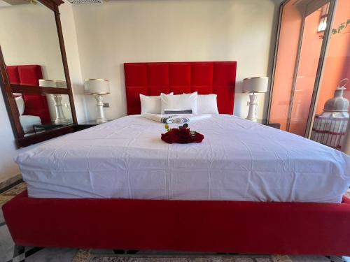 a bedroom with a large bed with a red headboard at Appart-Hotel luxe à l’hivernage in Marrakesh