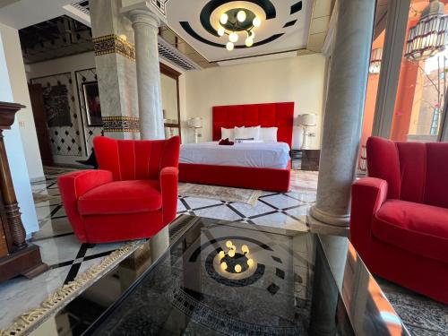 une chambre d'hôtel avec un lit et deux chaises dans l'établissement Appart-Hotel luxe à l’hivernage, à Marrakech