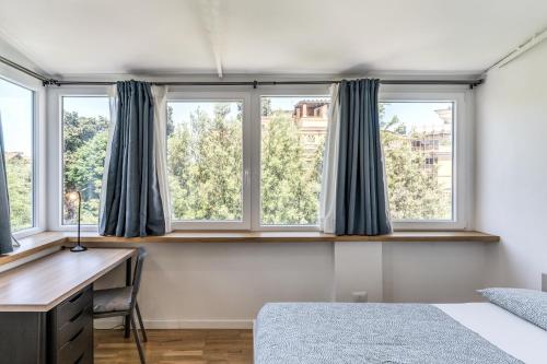 a bedroom with a desk and three windows at V E N E R E Apartments in Rome