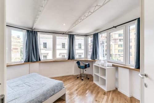 a bedroom with a bed and a desk and windows at V E N E R E Apartments in Rome