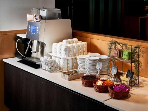a counter with plates and bottles and baskets on it at Daiwa Roynet Hotel Wakayama in Wakayama