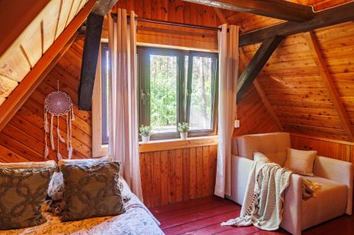 sypialnia w drewnianym domku z łóżkiem i oknem w obiekcie Frono nad Bugiem - dom na wynajem w mieście Sarnaki