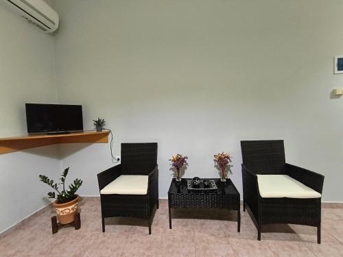 a living room with two chairs and a table at My Lemnos Studios - Studio 4 in Repanídhion