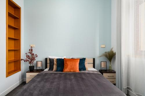 弗罗茨瓦夫Prestige Apartment - Elegant & Quiet Stay 3 rooms 90m2 - AS Home Apartamenty Rynek 508的一间卧室配有带橙色和蓝色枕头的床