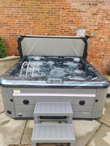 a large hot tub sitting in front of a brick wall at Rainworth Lodge in Nottingham