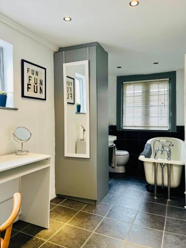 a bathroom with a tub and a toilet and a sink at Inglenook of Deal in Kent