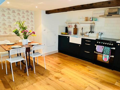 a kitchen with a table and chairs in a kitchen at Inglenook of Deal in Kent