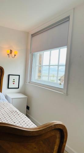 a bedroom with a window and a bed in a room at Inglenook of Deal in Kent