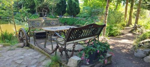 a park bench with a table and some flowers at Przysiółek Jabłonowice in Kierzkowo