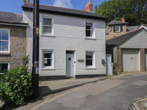 a white house on the side of a street at 2 Chapel Place in Mousehole