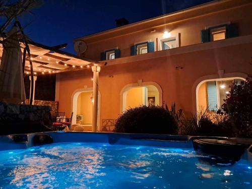 a swimming pool in front of a house at night at Villa Cesarica Novalja in Novalja