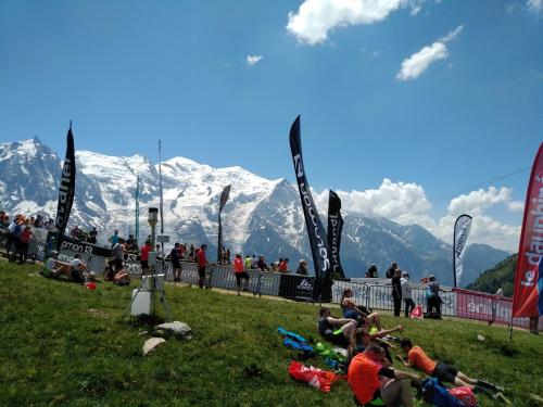 a group of people sitting in the grass with mountains in the background at Chalet Walser à VALLORCINE 13 kms CHAMONIX France in Vallorcine