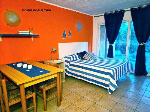 - une chambre avec des murs orange, un lit et une table dans l'établissement Studio apartment on the sea for couples or families, à Ghisonaccia