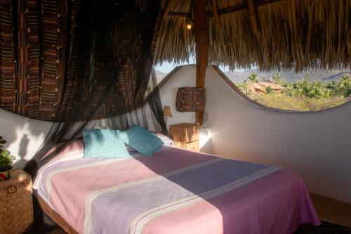 a bedroom with a bed and a large window at El MURO MAJAHUA RETREAT CENTER in La Majahua