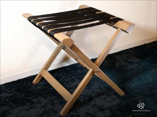 a wooden stool sitting next to a wall at Daiwa Roynet Hotel Wakayama in Wakayama