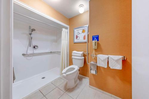 a bathroom with a toilet and a shower and a phone at Best Western Plus Stovall's Inn in Anaheim