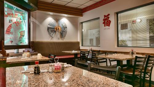 ein Restaurant mit Tischen und Stühlen und einem Ventilator an der Wand in der Unterkunft Best Western Pecos Inn in Artesia