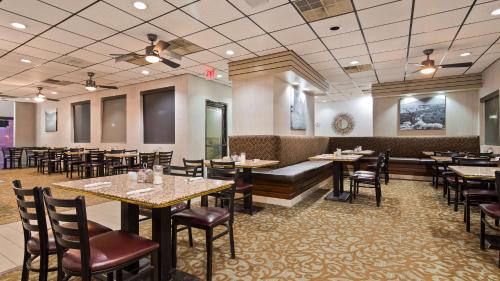 ein Restaurant mit Tischen und Stühlen und einer Couch in der Unterkunft Best Western Pecos Inn in Artesia