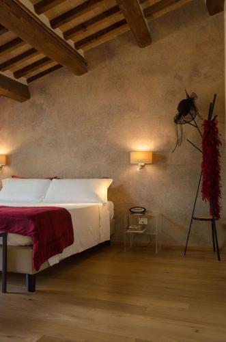a bedroom with a bed and two lights on the wall at Antico Sipario Boutique Hotel, BW Signature Collection in Paciano