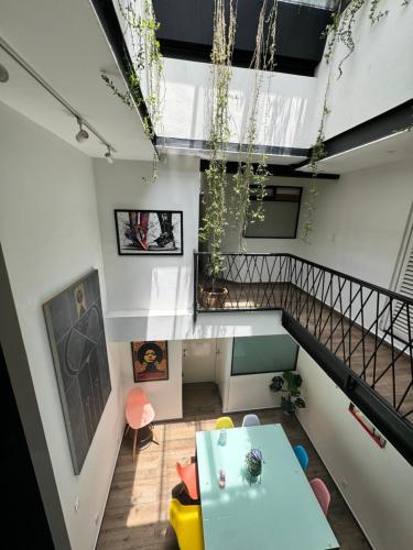 a living room with a table and a staircase at Calzolli Penthouse Casa de Huéspedes y Coliving in Mexico City