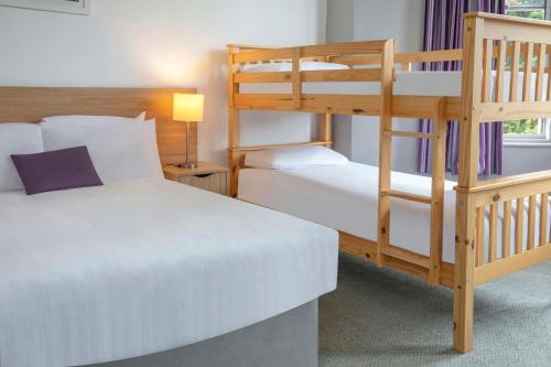 a bedroom with two beds and a bunk bed at Tor Park Hotel in Torquay