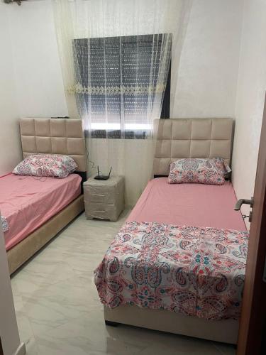 a bedroom with two beds and a window at Rhach alhoceima in Al Hoceïma