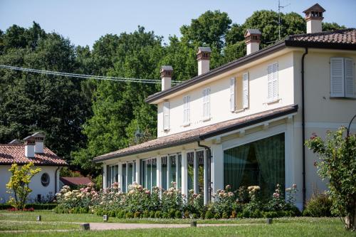 an old white house with windows and flowers at Villa Abbondanzi Resort in Faenza