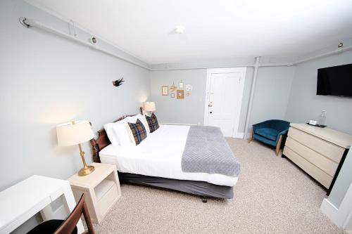 a bedroom with a bed and a flat screen tv at The New London Inn in New London