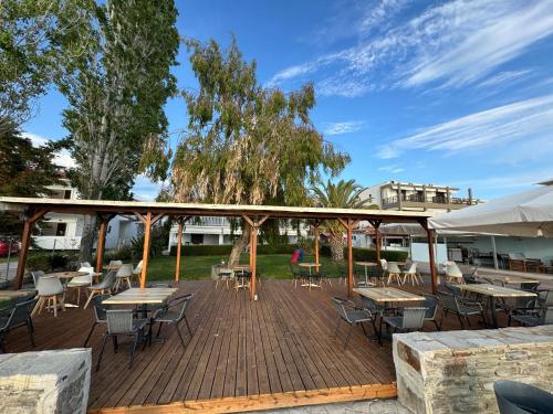 a wooden deck with tables and chairs on it at Regos Resort Hotel in Neos Marmaras