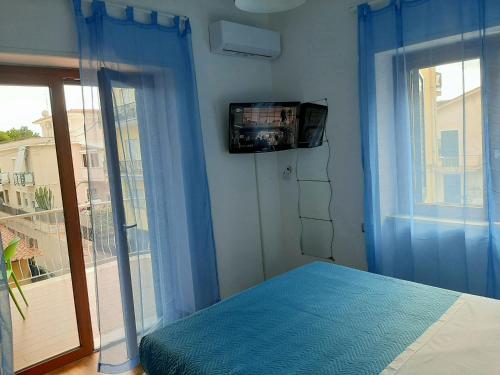 a bedroom with a bed and a tv on the wall at Casa Annalisa in Scauri